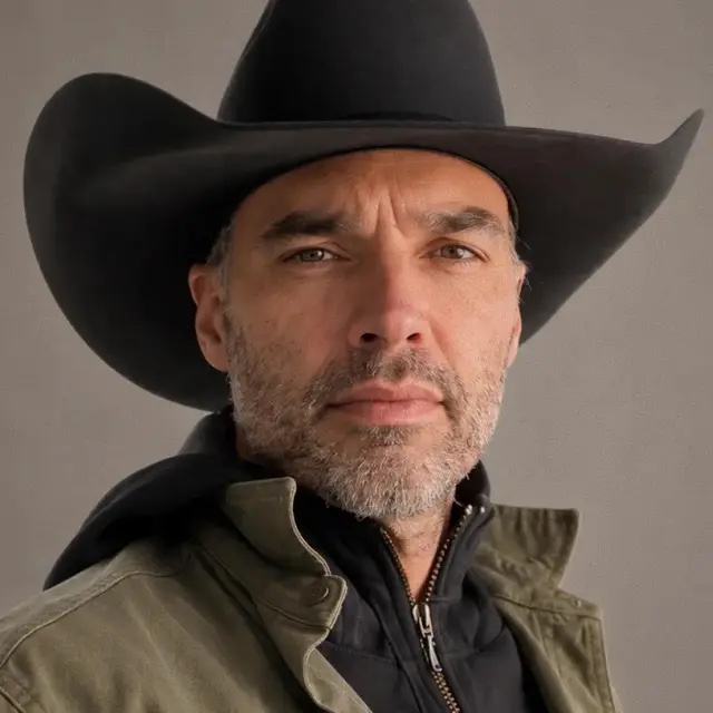 Ward Vuillemot in a black cowboy hat and canvas jacket, looking straight at the camera
